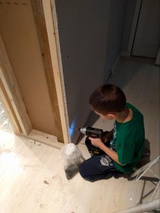 14 Oranges Kelton child using drill with drywall