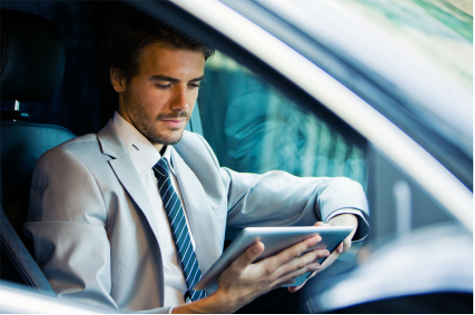 Handsome Young Businessman Using Digital Tablet in Car