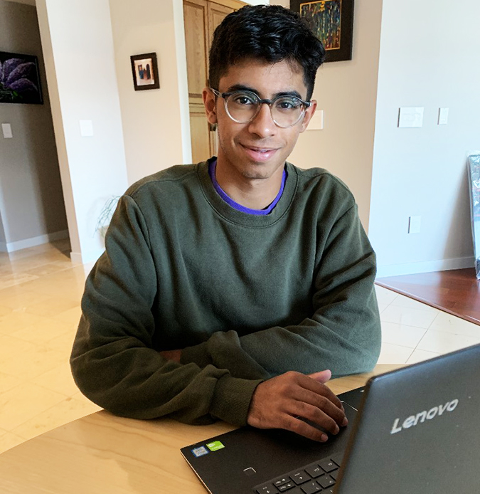 14 Oranges Yasin Ladha Looking at camera with laptop