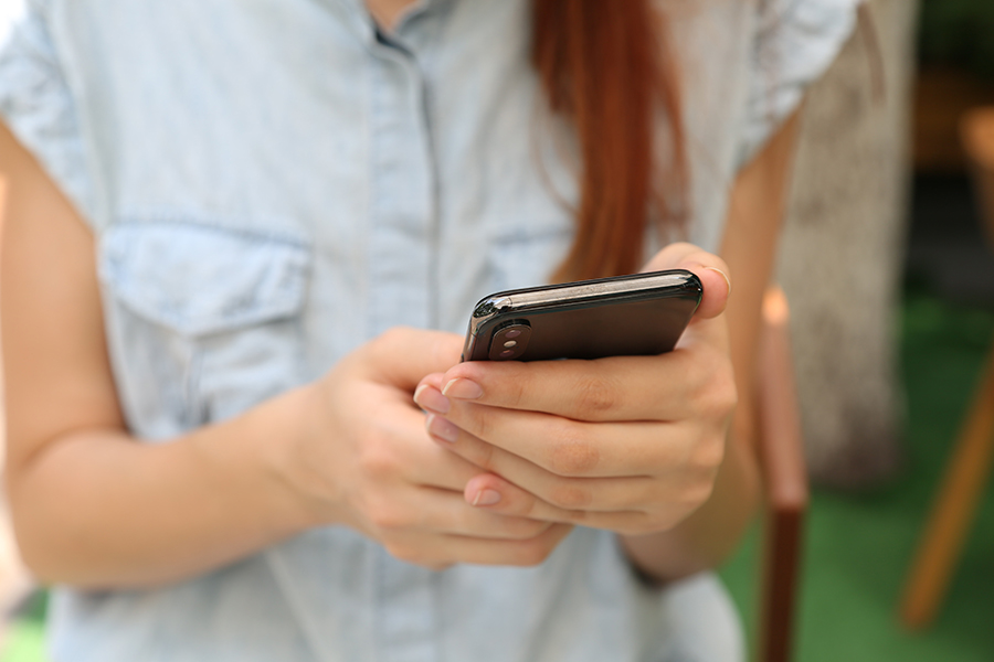 14 Oranges Blog Female User looking at Cellphone